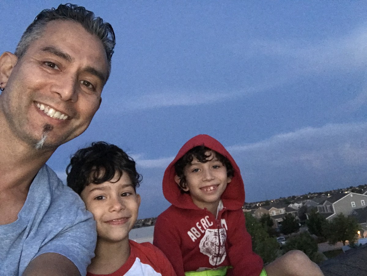 Chase with his dad and brother on a rooftop at dusk